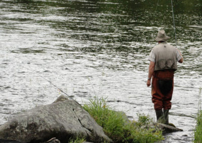 A person enjoying the summer fishing near the river